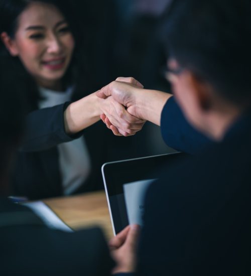 Two people shaking hands and smiling